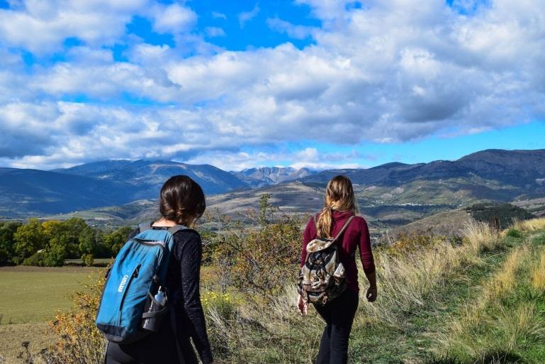 two women with backpacks hiking together