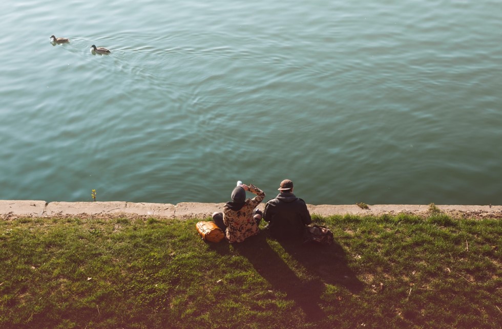 people sitting on the banks of a lake