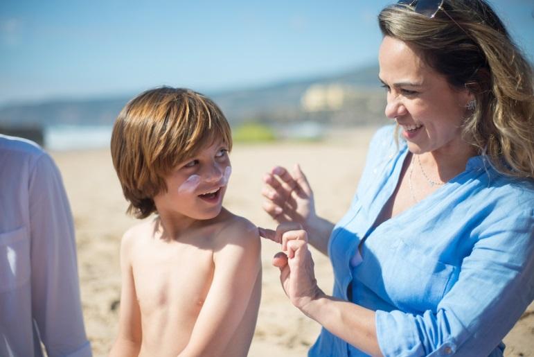 woman applying sunscreen on a child