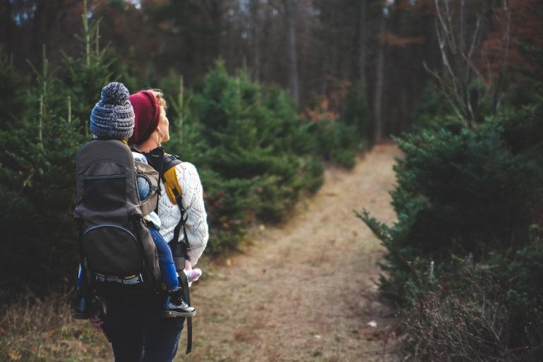 woman hiking with a child on her back