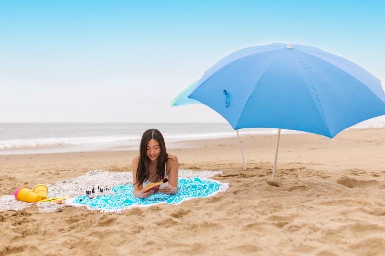 woman reading a book at the beach