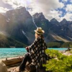 woman sitting on a rock beside a lake